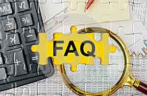 Puzzle with a calculator, magnifying glasses and financial documents in the center inscription -FAQ