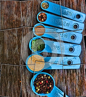 Puzzle effect Blue Measuring spoons with Spices on Wood