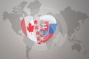 Puzzle heart with the national flag of canada and slovakia on a world map background.Concept