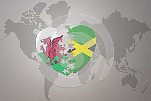 puzzle heart with the national flag of jamaica and wales on a world map background.Concept