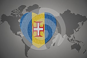 Puzzle heart with the national flag of madeira on a world map background