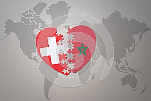puzzle heart with the national flag of morocco and switzerland on a world map background.Concept