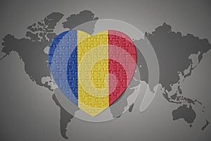 Puzzle heart with the national flag of romania on a world map background