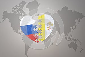 Puzzle heart with the national flag of russia and vatican city on a world map background. Concept