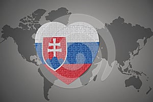 Puzzle heart with the national flag of slovakia on a world map background