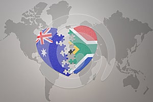 Puzzle heart with the national flag of south africa and australia on a world map background. Concept