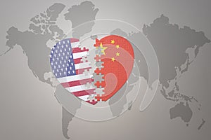 Puzzle heart with the national flag of united states of america and china on a world map background. Concept