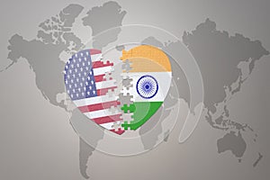 Puzzle heart with the national flag of united states of america and india on a world map background. Concept