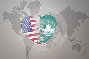 Puzzle heart with the national flag of united states of america and Macau on a world map background. Concept