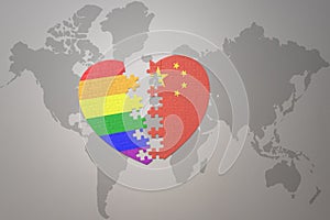 Puzzle heart with the rainbow gay flag and china on a world map background. Concept