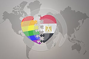 Puzzle heart with the rainbow gay flag and egypt on a world map background. Concept
