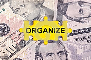 Puzzle with the image of dollars in the center of the inscription -ORGANIZE