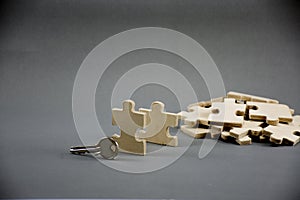 Puzzle made of wood with key.on gray background with business idea,MLM business or Businessman Steps to Success or background for