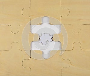 A puzzle made of wood with a too small piece in the middle