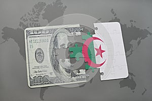 puzzle with the national flag of algeria and dollar banknote on a world map background.