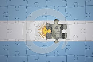 puzzle with the national flag of argentina and usa dollar banknote. finance concept