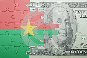 Puzzle with the national flag of burkina faso and dollar banknote