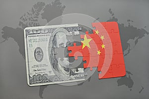 puzzle with the national flag of china and dollar banknote on a world map background.