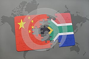 puzzle with the national flag of china and south africa on a world map background.