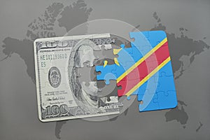 puzzle with the national flag of democratic republic of the congo and dollar banknote on a world map background.