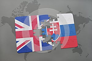 Puzzle s národní vlajkou Velké Británie a slovenska na pozadí mapy světa