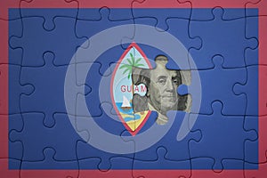 puzzle with the national flag of guam and usa dollar banknote. finance concept
