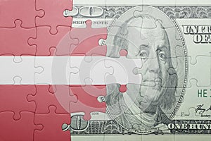 Puzzle with the national flag of latvia and dollar banknote