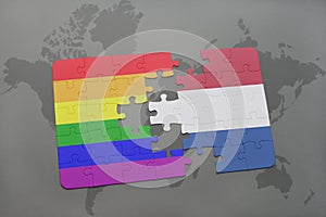 puzzle with the national flag of netherlands and gay rainbow flag on a world map background.