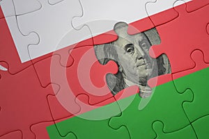 puzzle with the national flag of oman and usa dollar banknote. finance concept