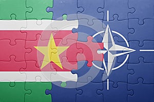 Puzzle with the national flag of suriname and nato