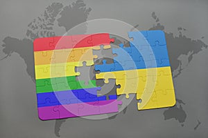 puzzle with the national flag of ukraine and gay rainbow flag on a world map background.