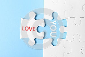 Puzzle with phrase LOVE YOU on blue background, top view