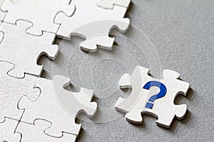 Puzzle piece with question mark, missing piece, business concept