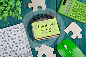 Puzzle pieces, calculator, note pad with text & x22;Financial tips& x22;, computer keyboard