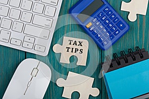 Puzzle pieces with text & x22;Tax tips& x22;, calculator, note pad, computer keyboard