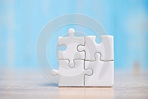 Puzzle pieces on wood table background. Business solutions, mission target, successful, goals, cooperation, partnership and