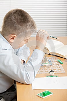 Puzzled boy looking at curcuit