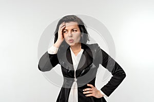 Puzzled businesswoman in black formal jacket white shirt looking dejected, standing over white background. Small business owners,