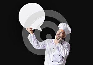 Puzzled Chef Holding White Speech Bubble Standing Over Black Background