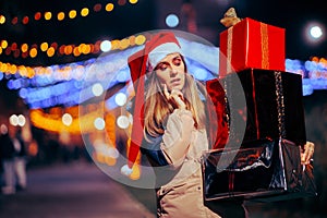 Puzzled Christmas Woman holding a big Pile of Gift Boxes