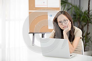 Asian woman thinking hard concerned about online problem.