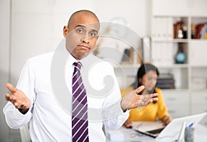 Puzzled and confused office employee making helpless gesture