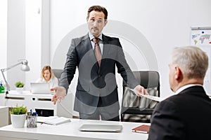 Puzzled employer having conversation with colleague in the office