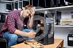 Puzzled handsome man cannot solve the computer problem