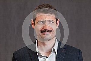 Puzzled looking man with a short mustache