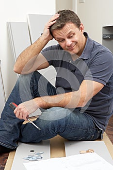 Puzzled Man Assembling Flat Pack Furniture