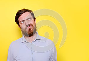 Puzzled man face expression isolated on yellow