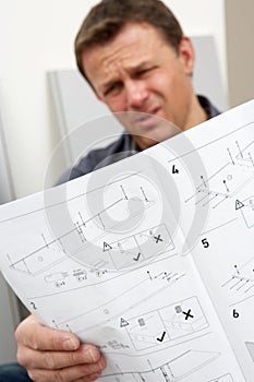 Puzzled Man Reading Assembly Furniture Instruction photo