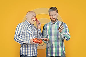 puzzled men with telephone contrast call in studio. men with telephone contrast call