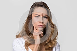 Puzzled perplexed woman with frowning face isolated on studio wall